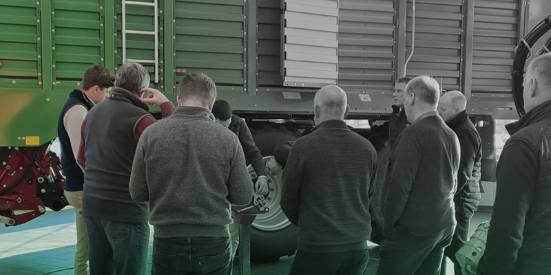 Customers stood in front of a Strautmann Forage Wagon, receiving training